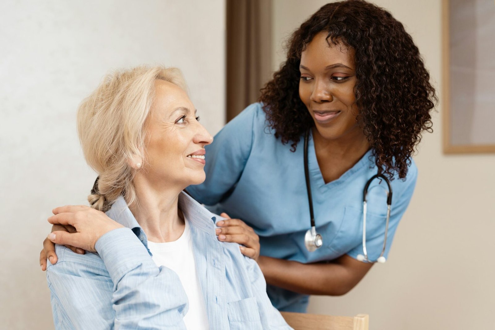 Nurse Comforting Elderly Woman in Healthcare Setting, Smiling and Caring