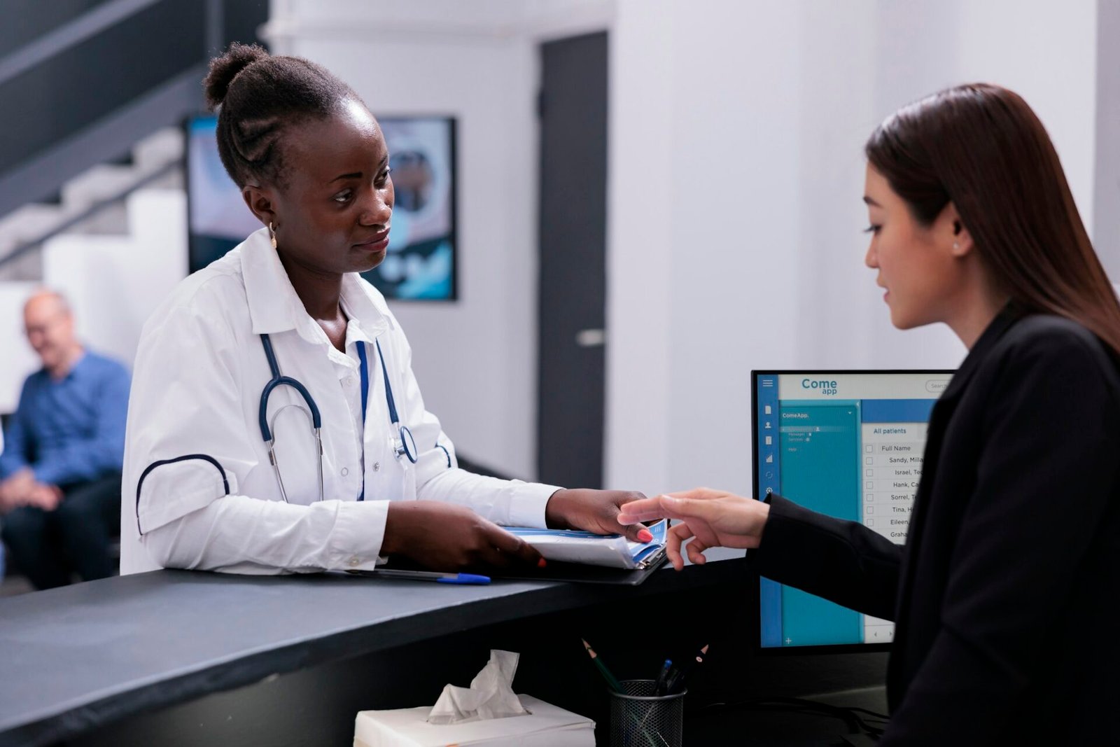 Receptionist helping physician doctor with checkup visit appointments while working at hospital